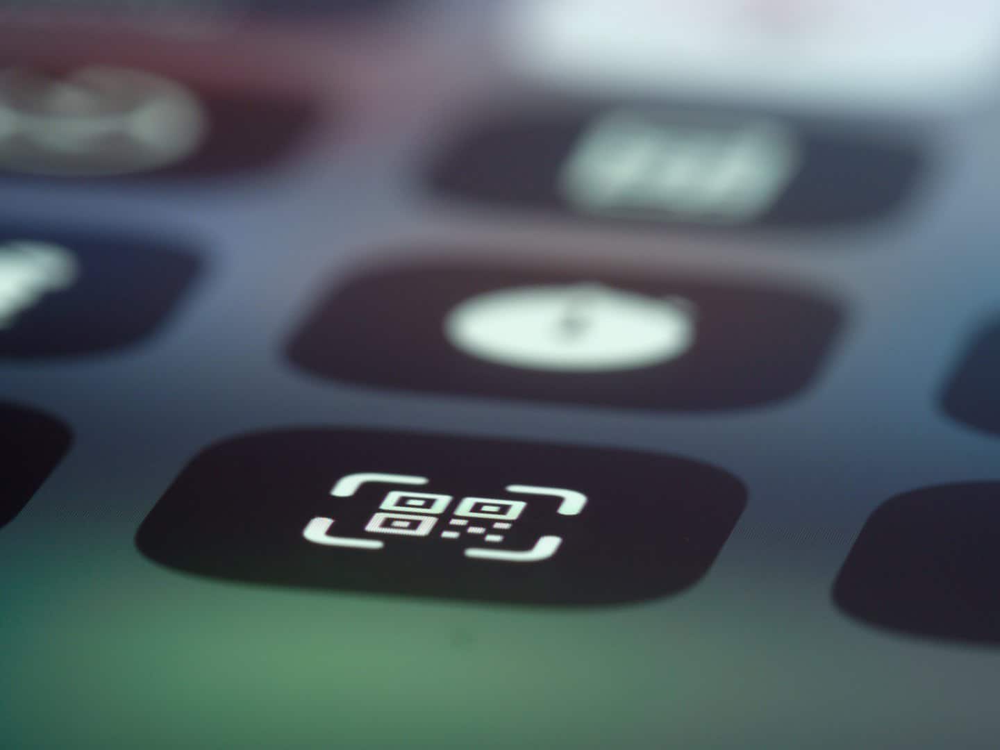 Icona scanner codice QR bianca su schermo digitale scuro.